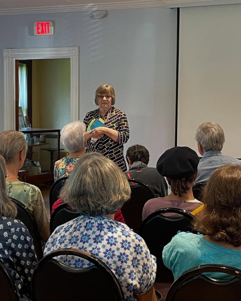 photo of Gwen presenting her book to a group.